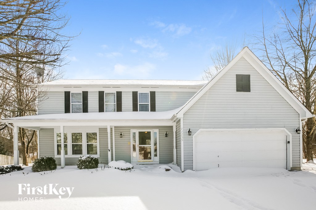 A white house with a snowy front yard.