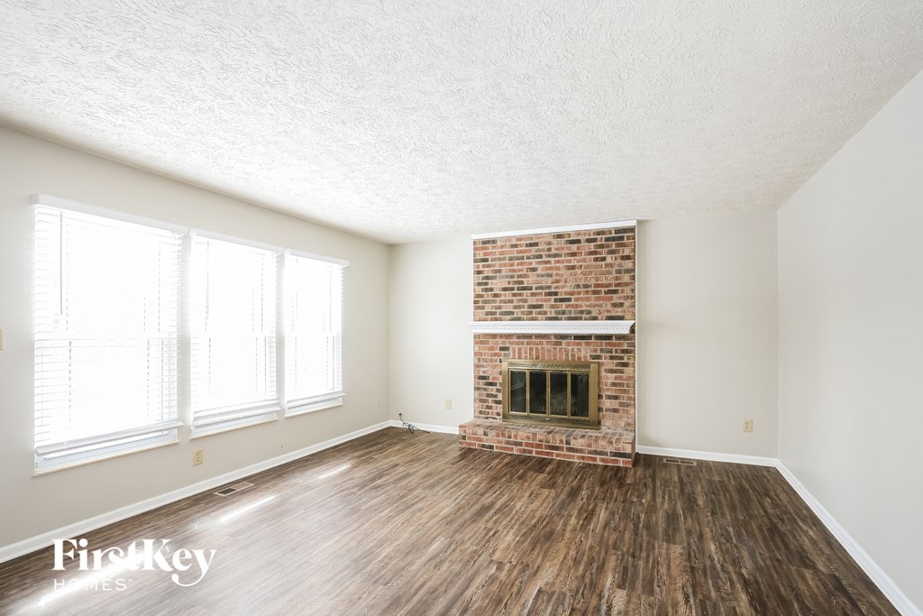 A room with a fireplace and wooden floors.