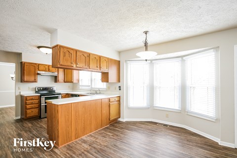 A kitchen with wooden cabinets and a stove top oven.