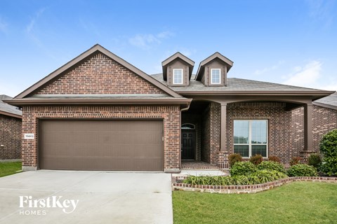 A brick house with a garage door and a window.