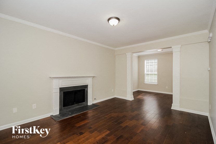 A room with a fireplace and wooden floors.