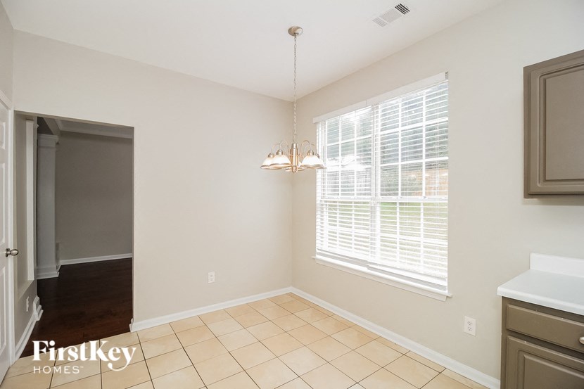 A room with a tiled floor and a chandelier hanging from the ceiling.