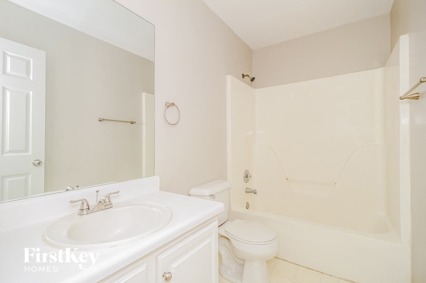 A white bathroom with a toilet, sink, and bathtub.