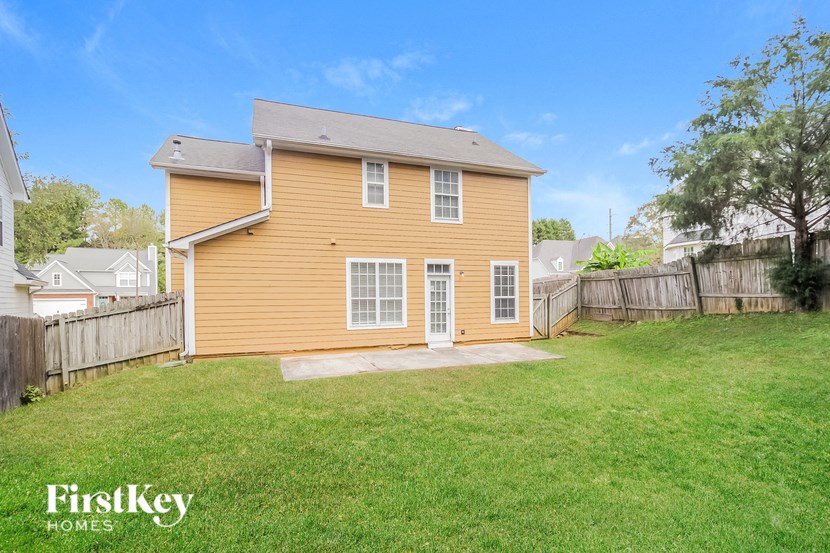 A house with a brown siding and a white roof is for sale.