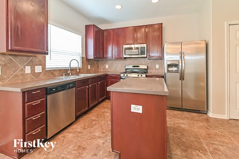 A kitchen with wooden cabinets and a stainless steel refrigerator.