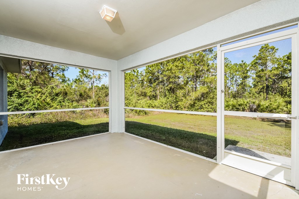 A sunny room with a view of trees and grass.