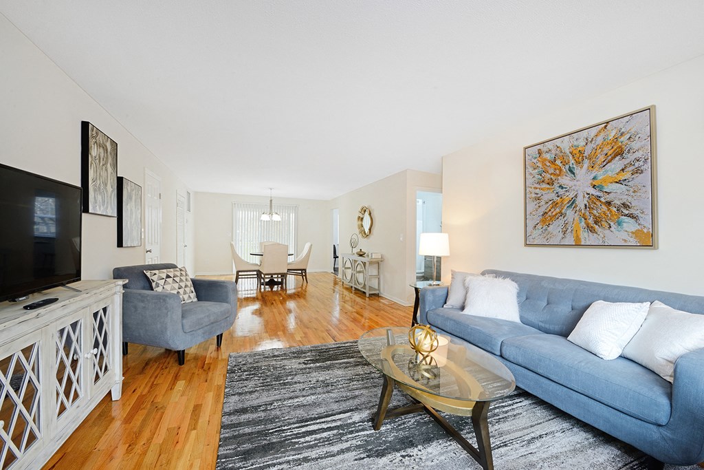 a living room with a blue couch and a glass coffee table