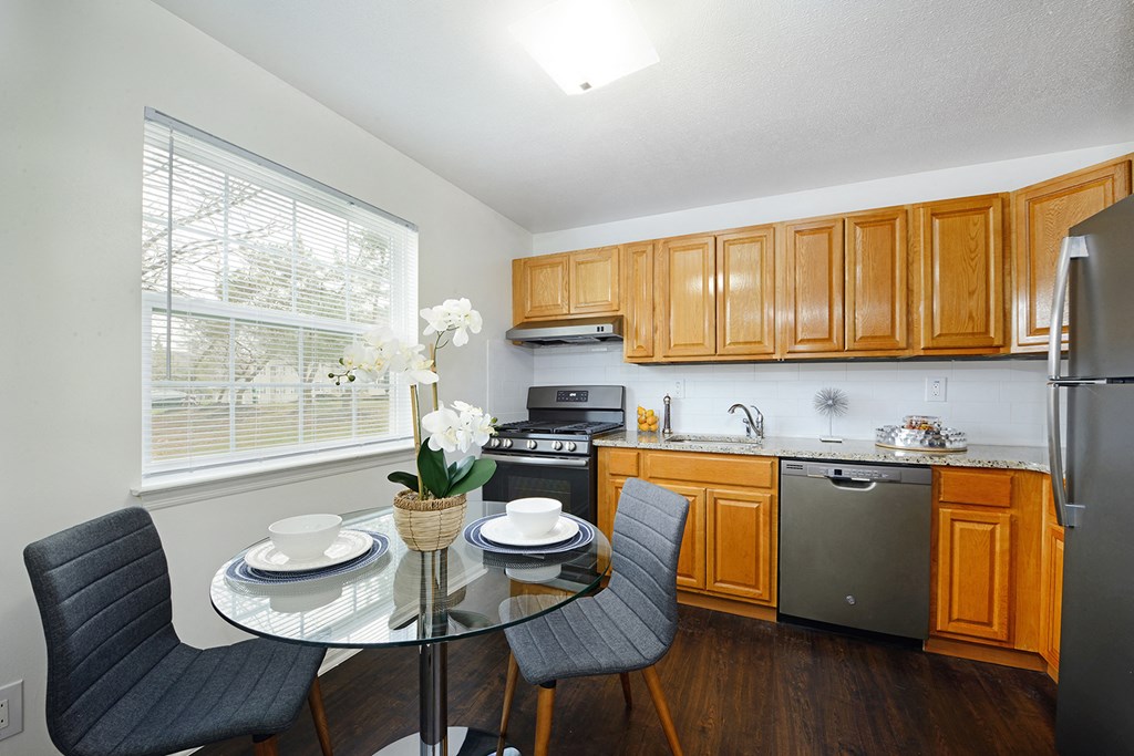 a kitchen and dining room with a glass table and chairs