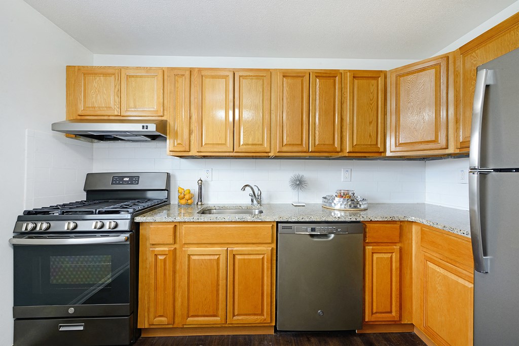 a kitchen with wooden cabinets and stainless steel appliances