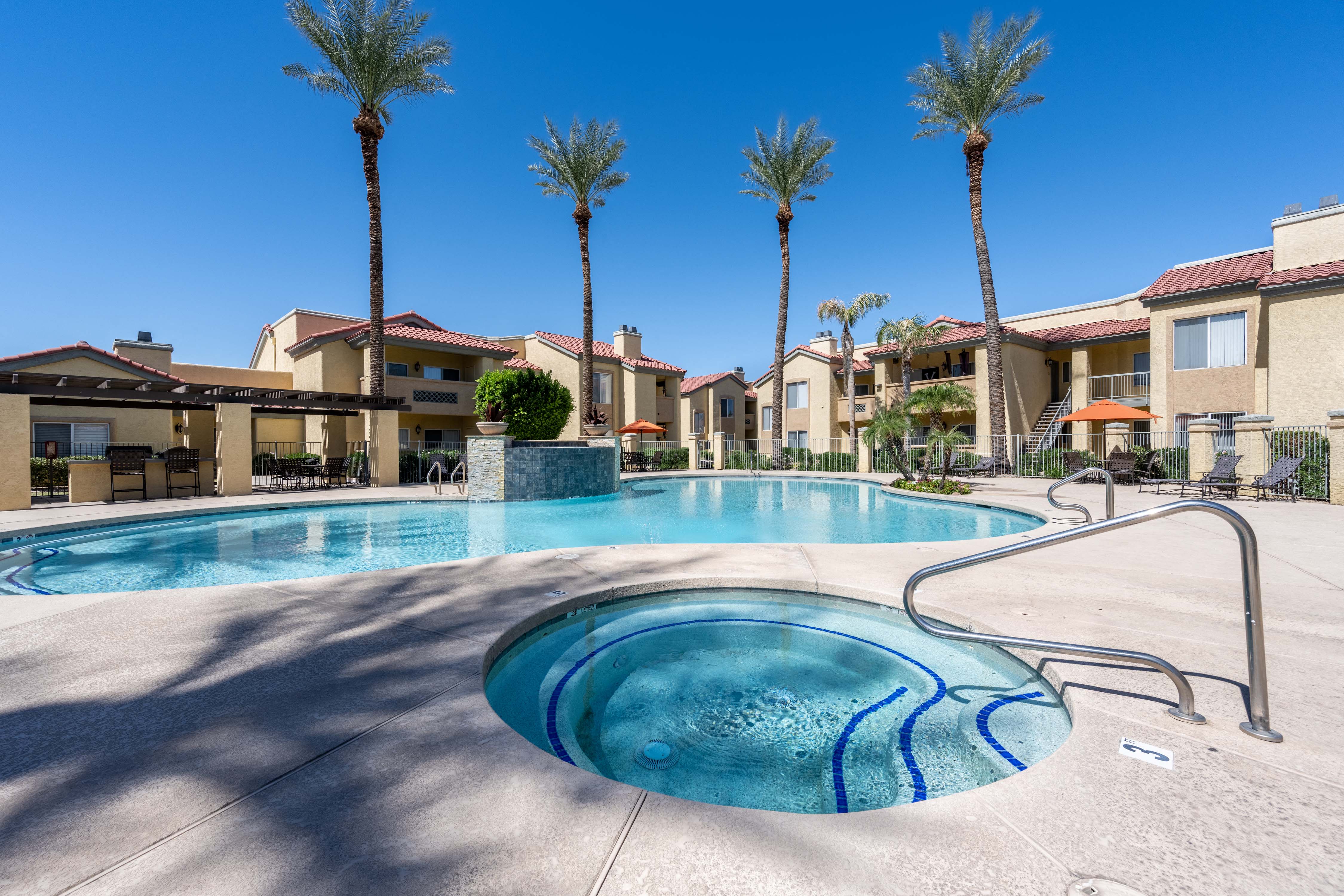 a swimming pool with palm trees and buildings in the background