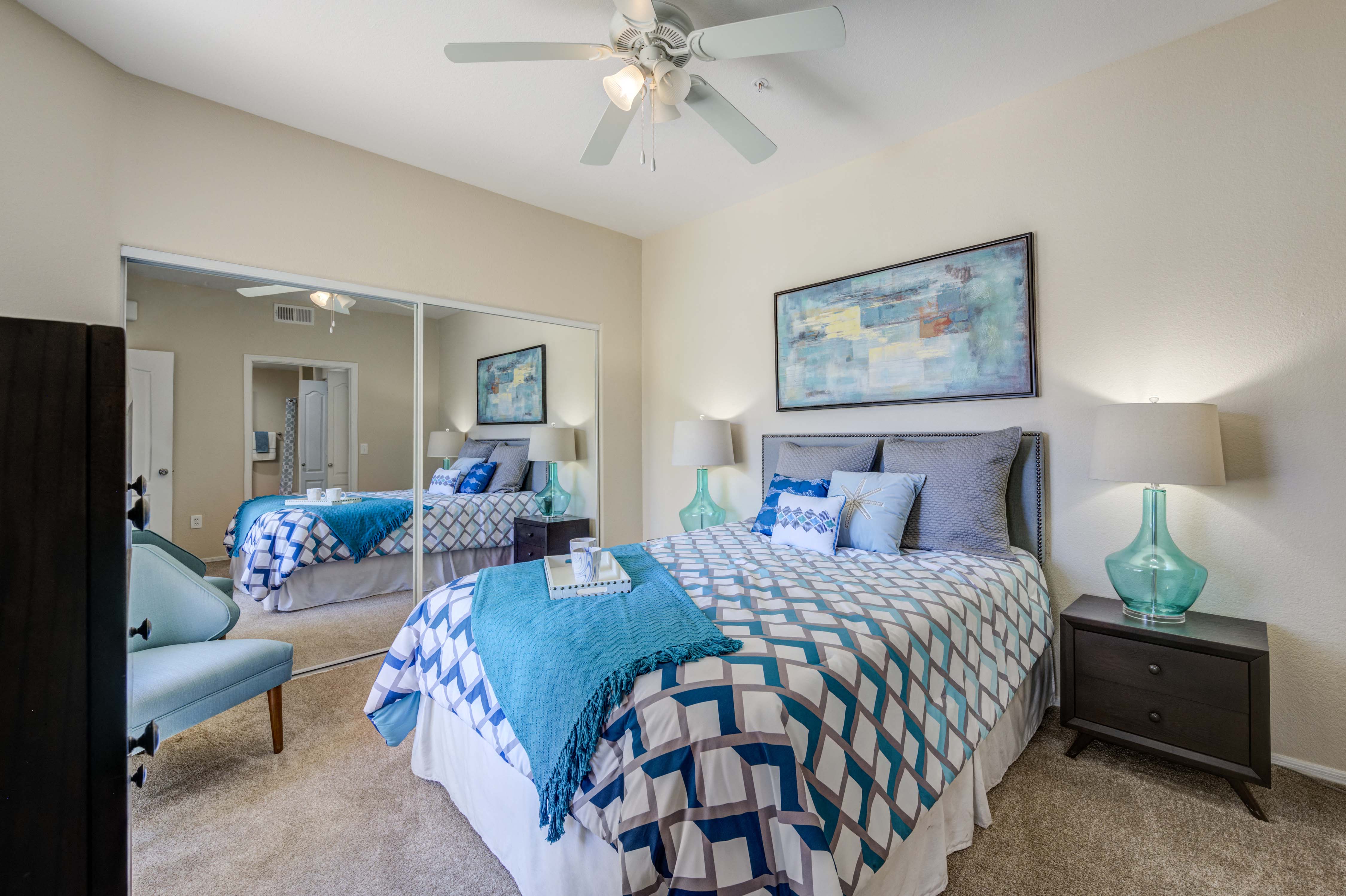 a bedroom with a large bed and a ceiling fan