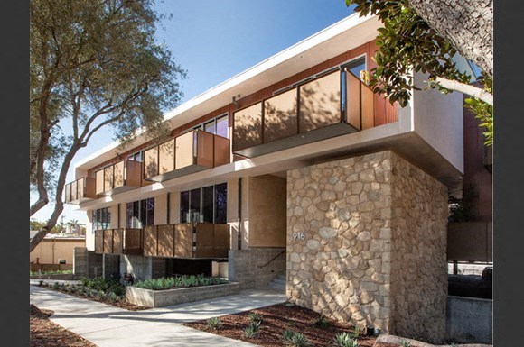 a house with a stone facade and a tree