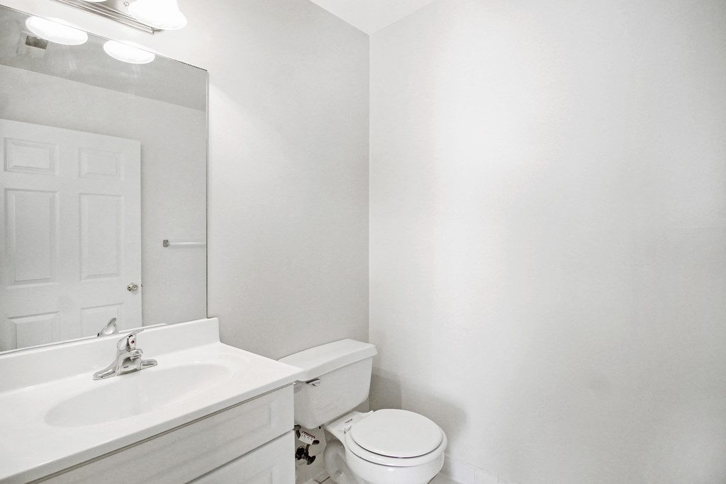 a bathroom with a sink toilet and a mirror