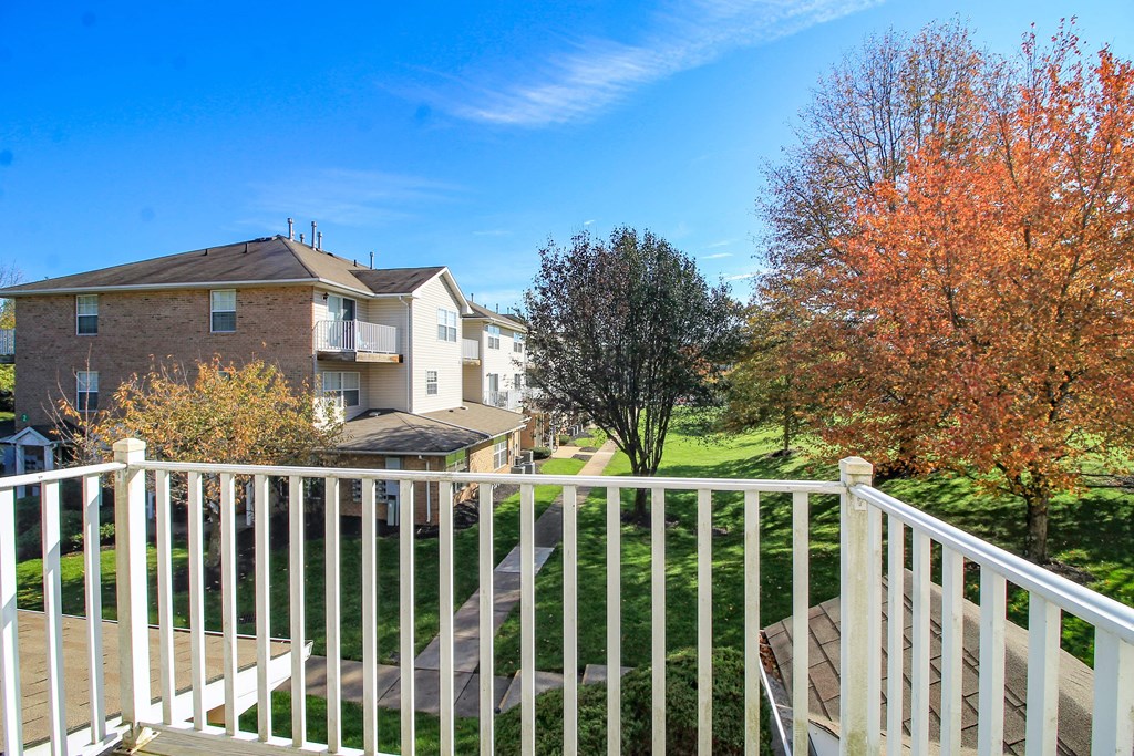 the view of a house from a balcony with a white railing
