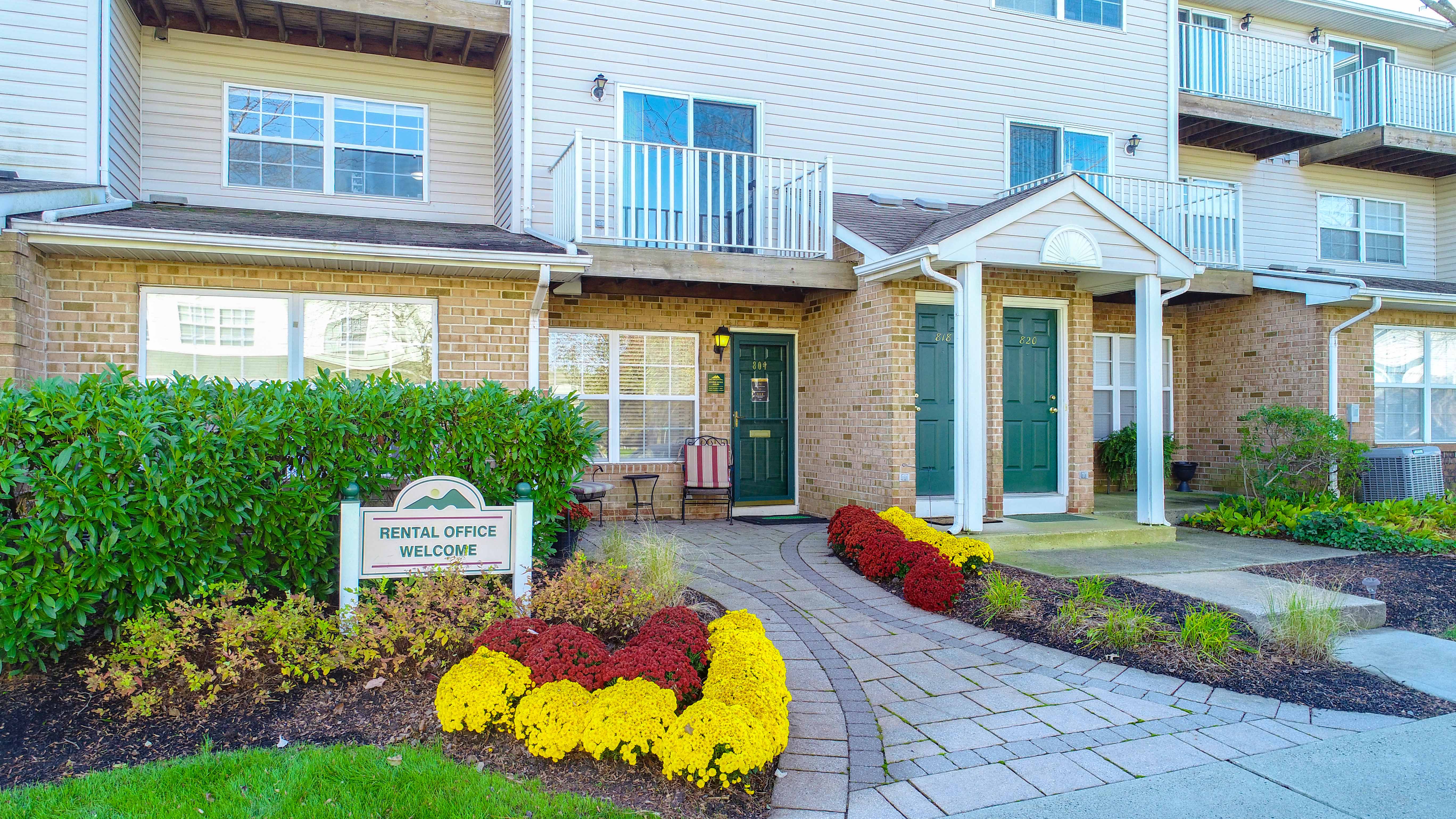 the front of a house with a walkway and flowers in front of it