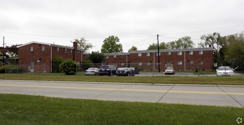 A parking lot in front of a brick building.