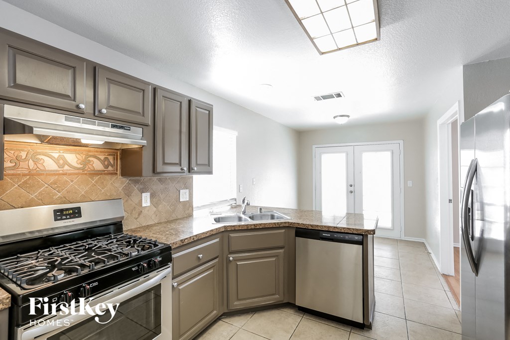 A kitchen with a stove top oven and a dishwasher.
