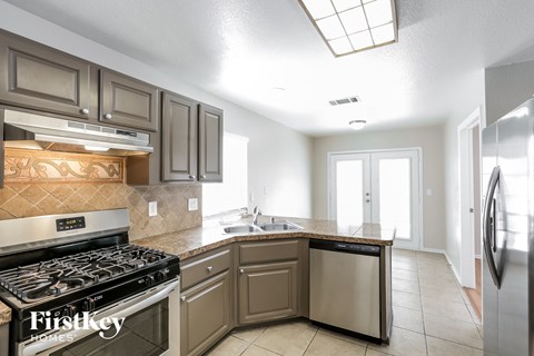 A kitchen with a stove top oven and a dishwasher.