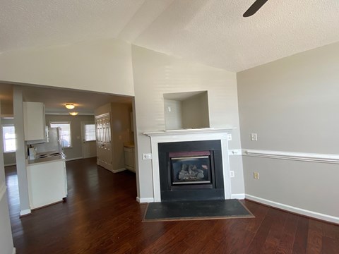 A living room with a fireplace and wood floors.
