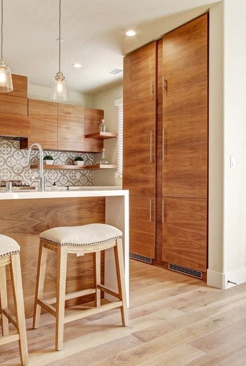 a kitchen with a bar stool and a refrigerator