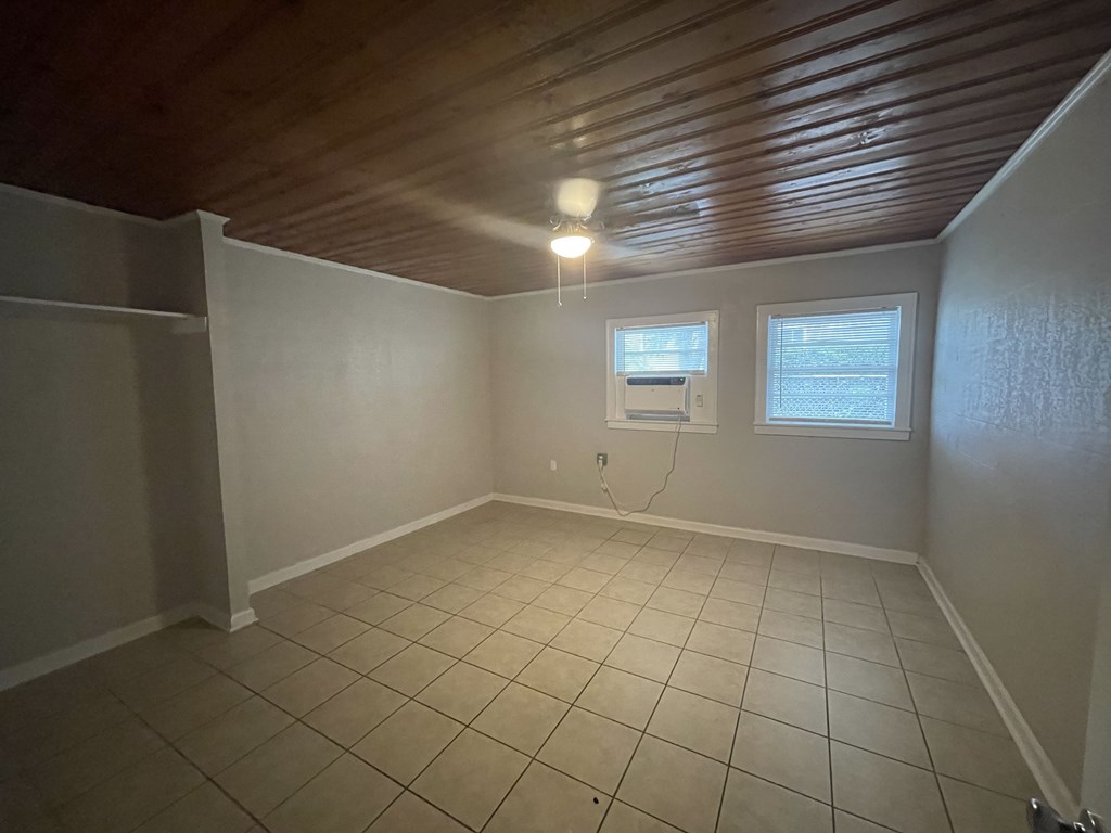 an empty living room with a tiled floor and a window