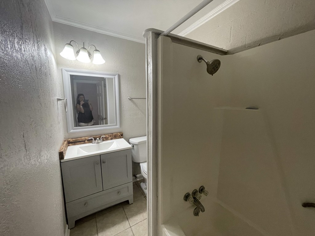 a bathroom with a shower and a sink and a mirror