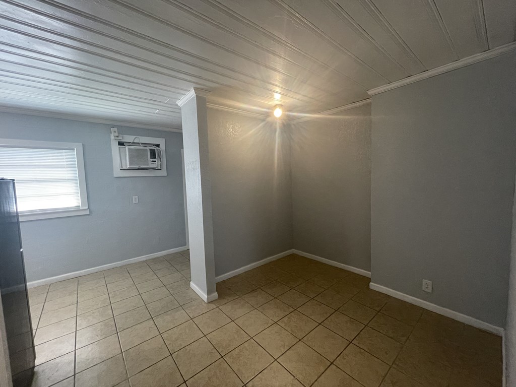 an empty room with a tiled floor and a window