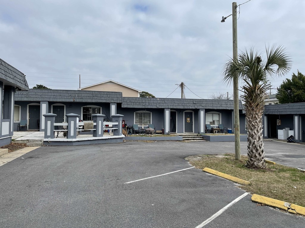 a building with a parking lot and palm trees in front of it