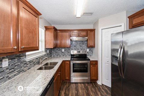 a kitchen with wood cabinets and granite counter tops and stainless steel appliances
