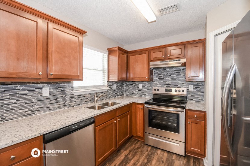 a kitchen with wooden cabinets and stainless steel appliances