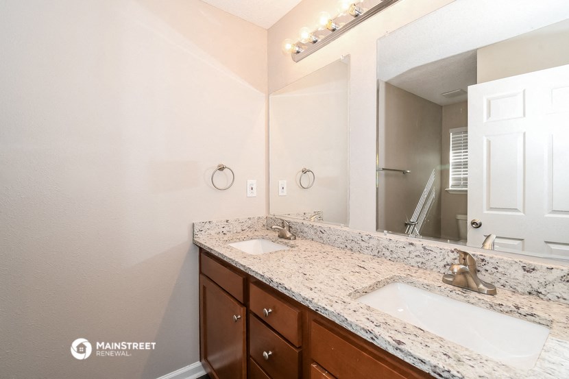 a bathroom with two sinks and a large mirror