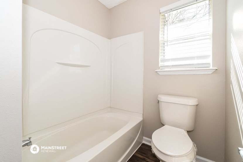a small bathroom with a toilet and a bath tub