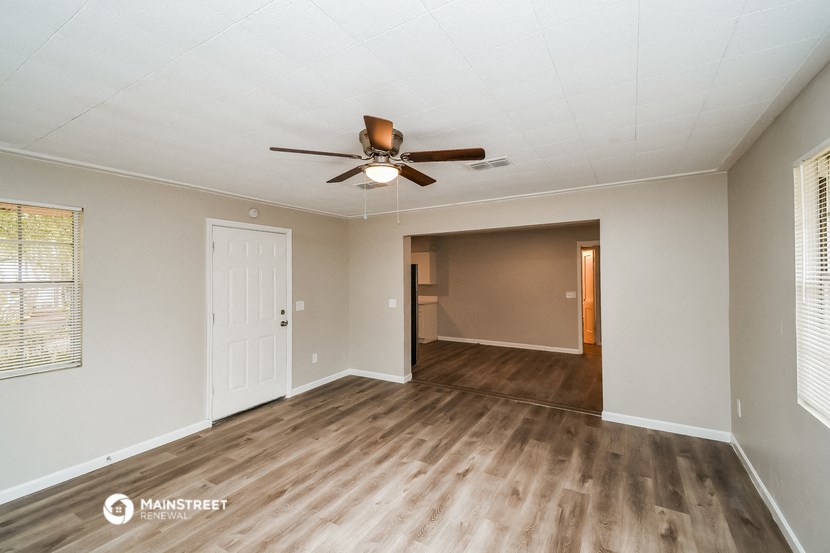 the living room and dining room of a manufactured home with a ceiling fan