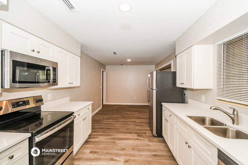 a kitchen with white cabinets and stainless steel appliances