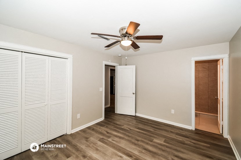 a bedroom with a ceiling fan and a closet