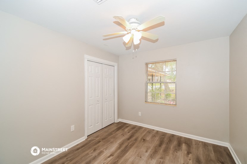 a bedroom with a ceiling fan and a window