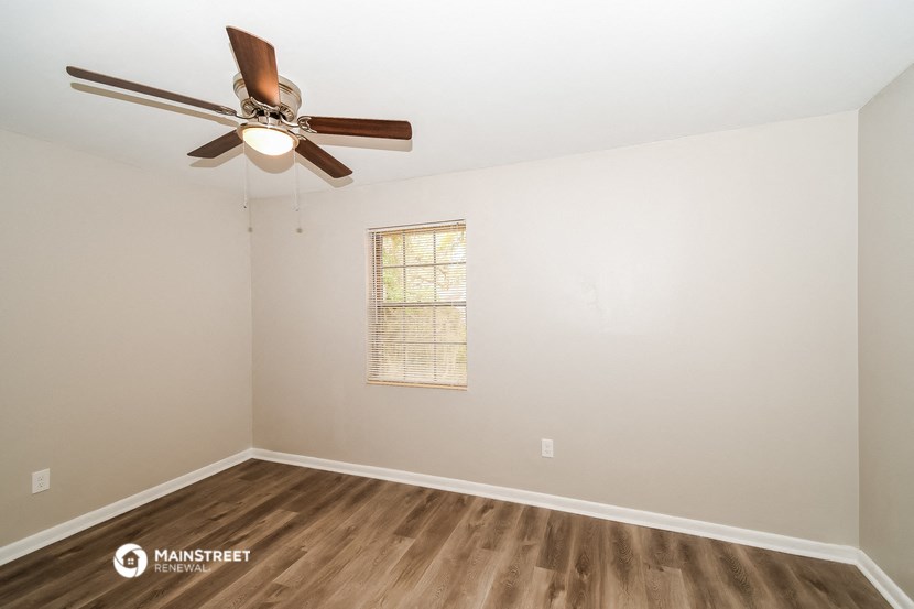 a living room with a ceiling fan and a window