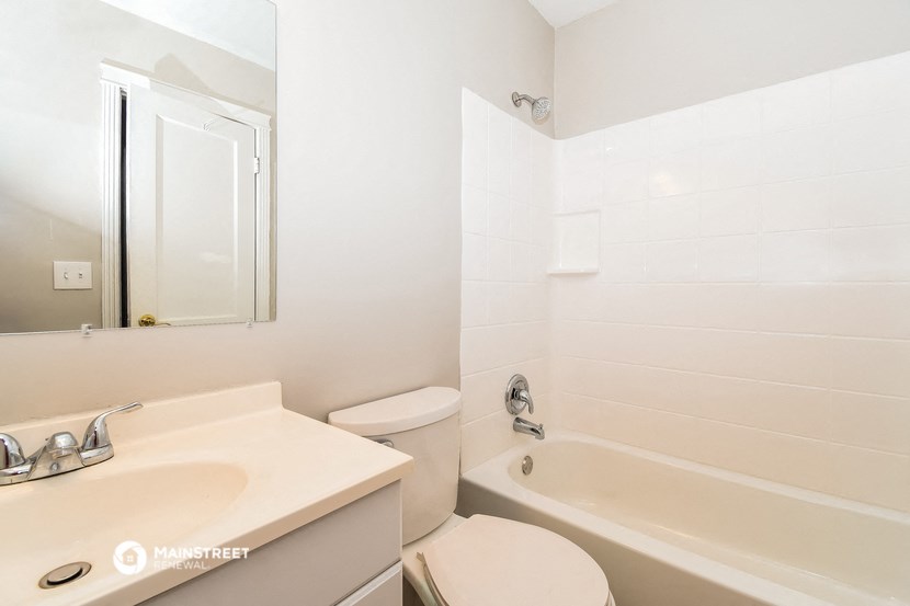 a bathroom with a toilet and a tub and a sink