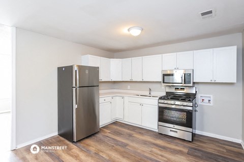 a kitchen with stainless steel appliances and white cabinets