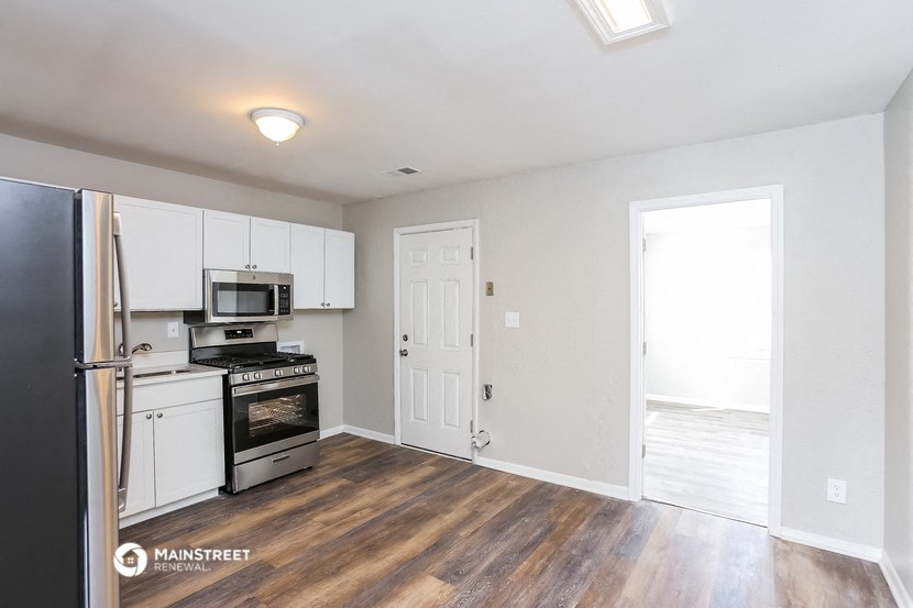 a kitchen with white cabinets and a stove and a refrigerator