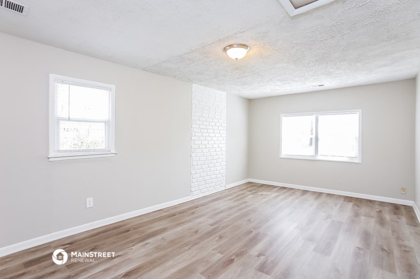 the living room of an empty house with wood flooring