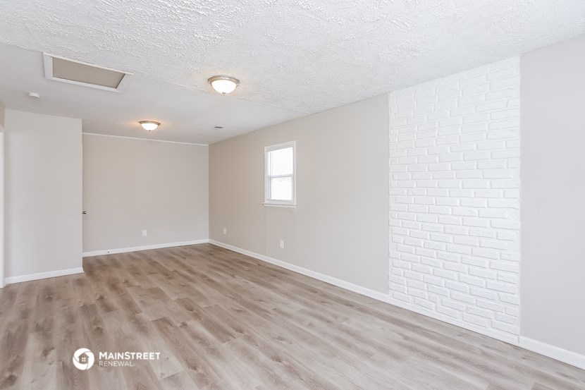 an empty living room with white walls and wood floors
