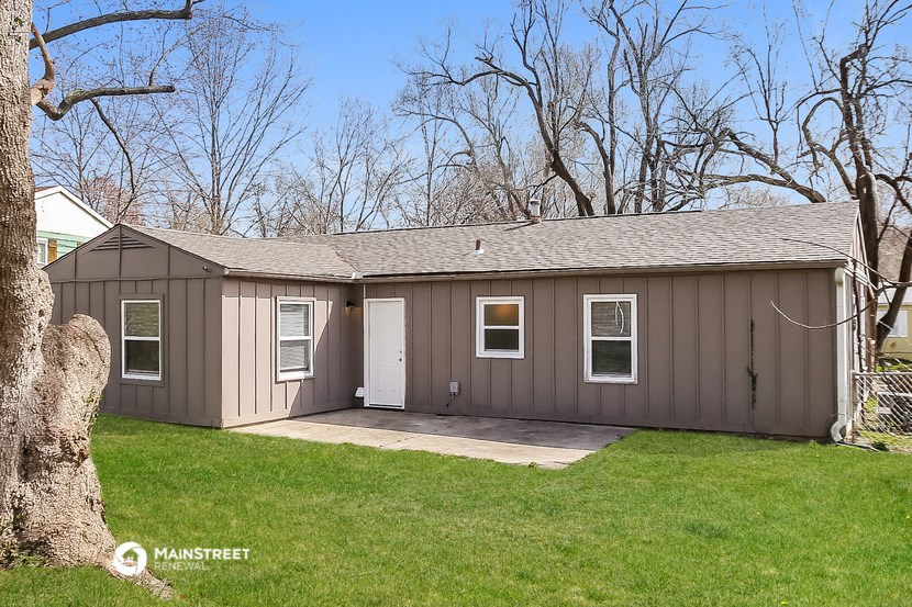 a brown shed with a white door and a grass yard