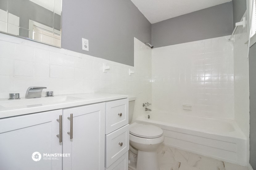 a white bathroom with a tub and a sink and a toilet