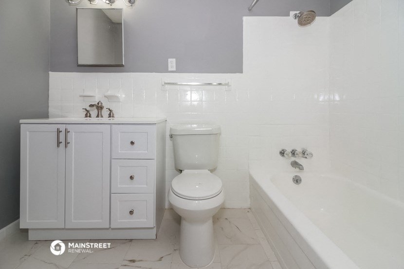 a white bathroom with a toilet and a tub and a sink