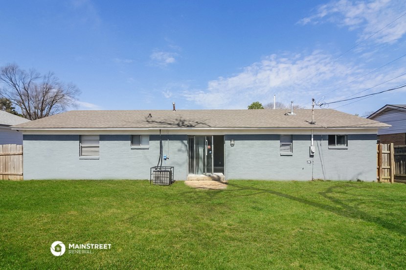 a white house with a grassy yard and a blue sky