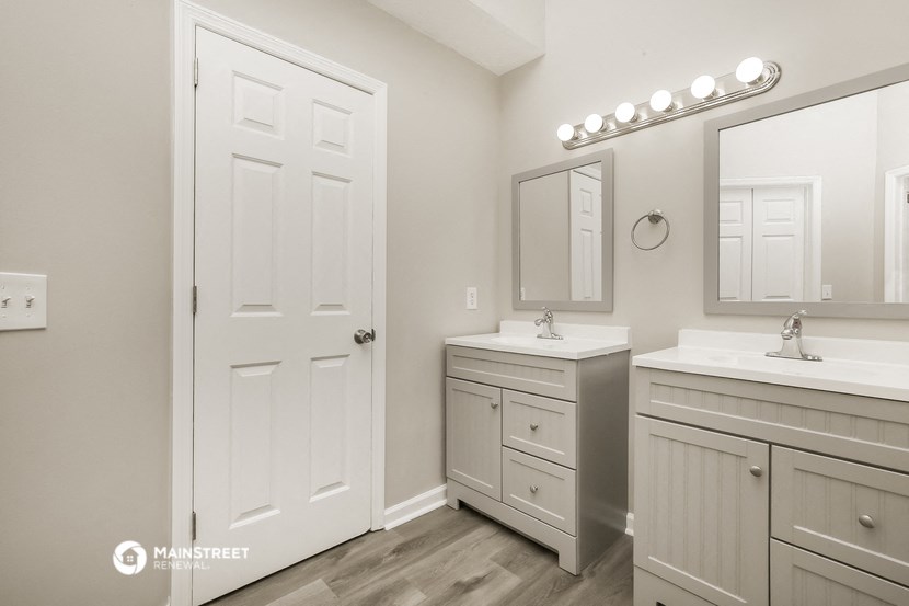 a white bathroom with two sinks and a mirror