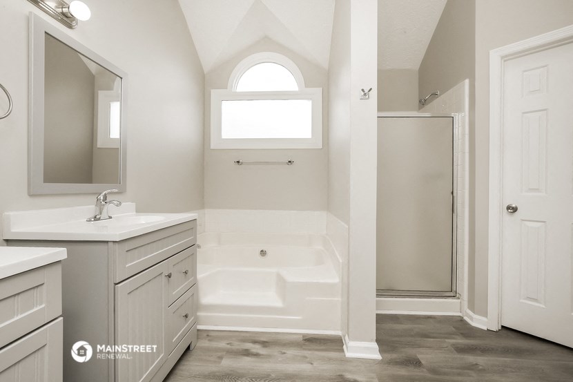 a white bathroom with a shower and a sink