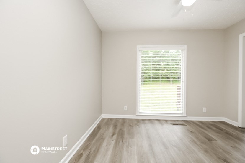 an empty room with wood floors and a window