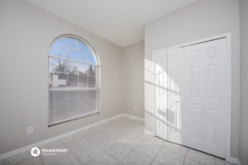 an empty room with a large window and a white door